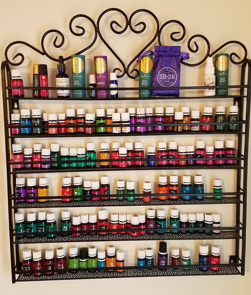 Metal wall rack filled with bottles of essential oils.